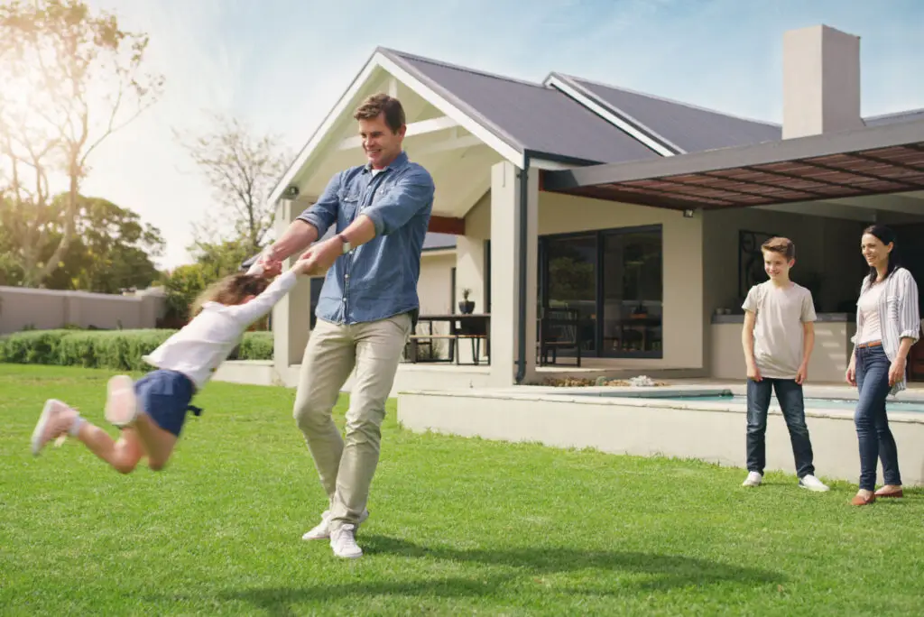 Shot Of A Happy Young Family Playing Together In Their Front Yard