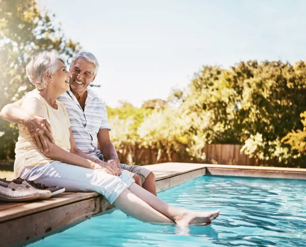 Shot Of A Happy Senior Couple Relaxing Together By The Poolside