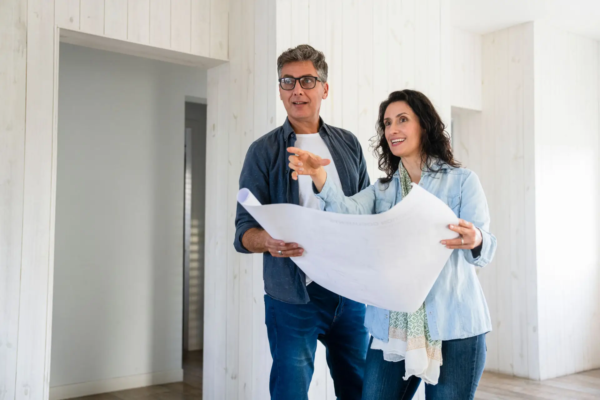 Mid Shot View Of Couple Assessing Ideas For Home Renovations